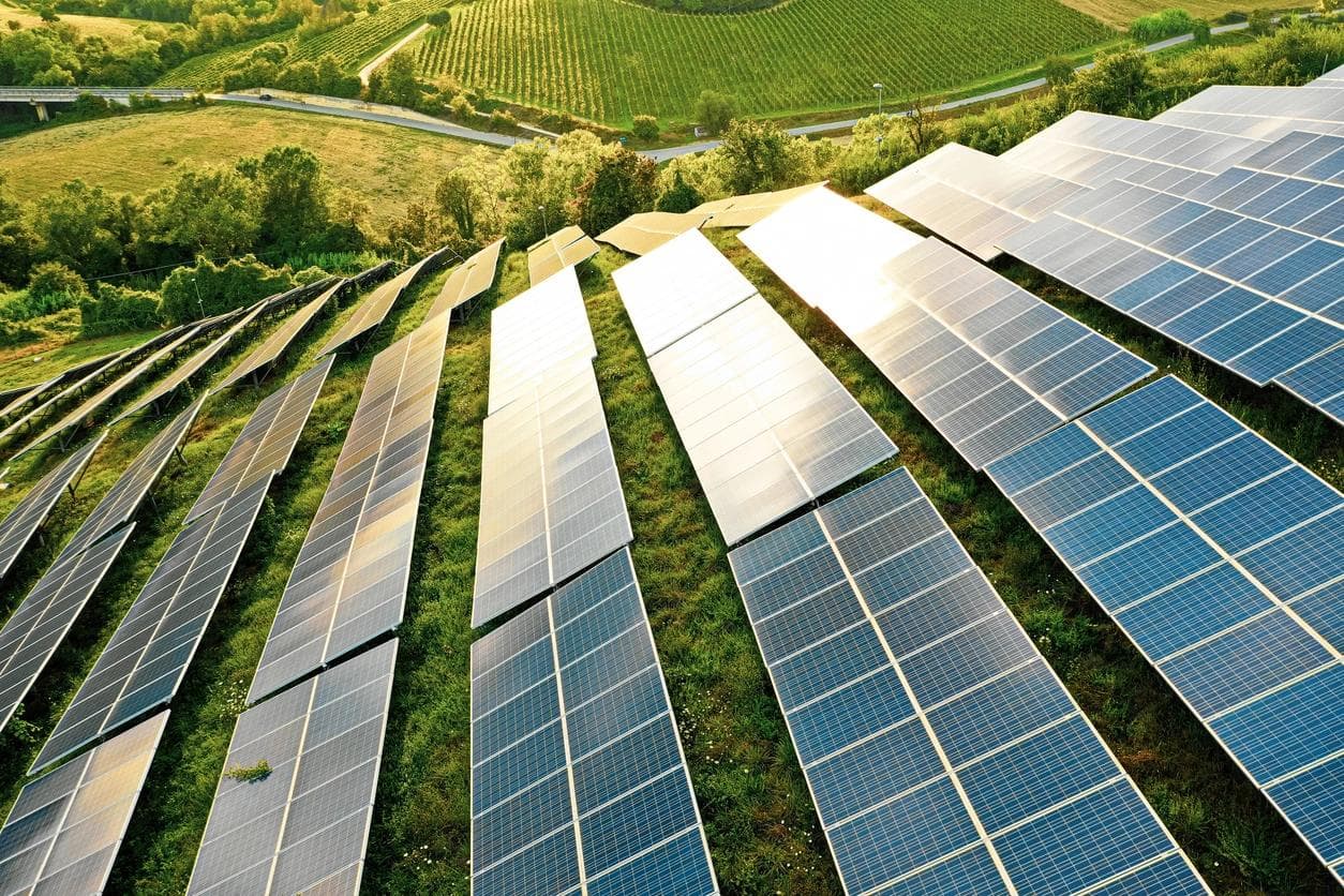 Panneaux solaires dans des champs de collines verdoyantes.