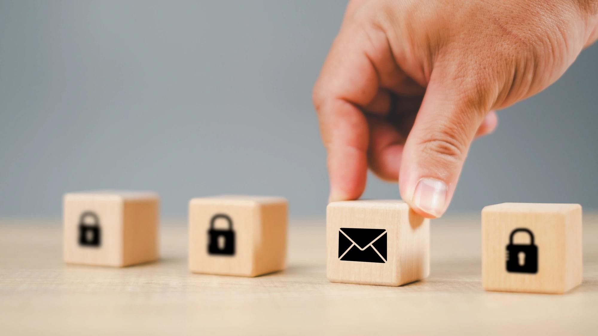 Blocs de bois illustrant des icônes d’enveloppe et de cadenas, symbolisant les contrôles de cybersécurité.