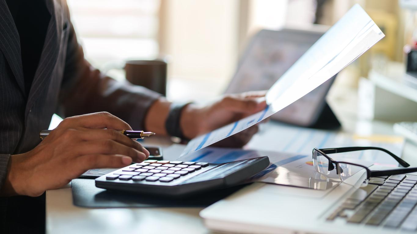 Young man using calculator for refinancing