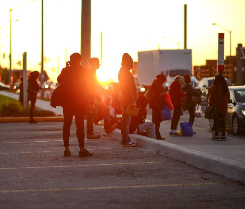 les gens attendent au coucher du soleil